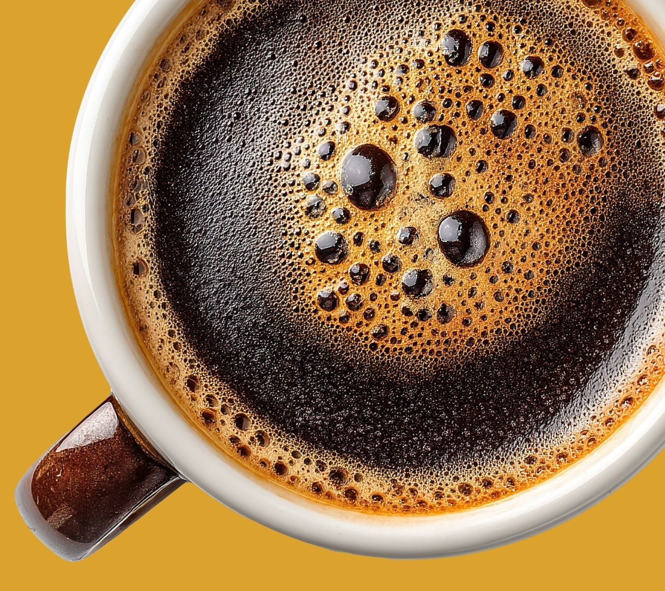 Coffee cup filled with coffee on a yellow background.
